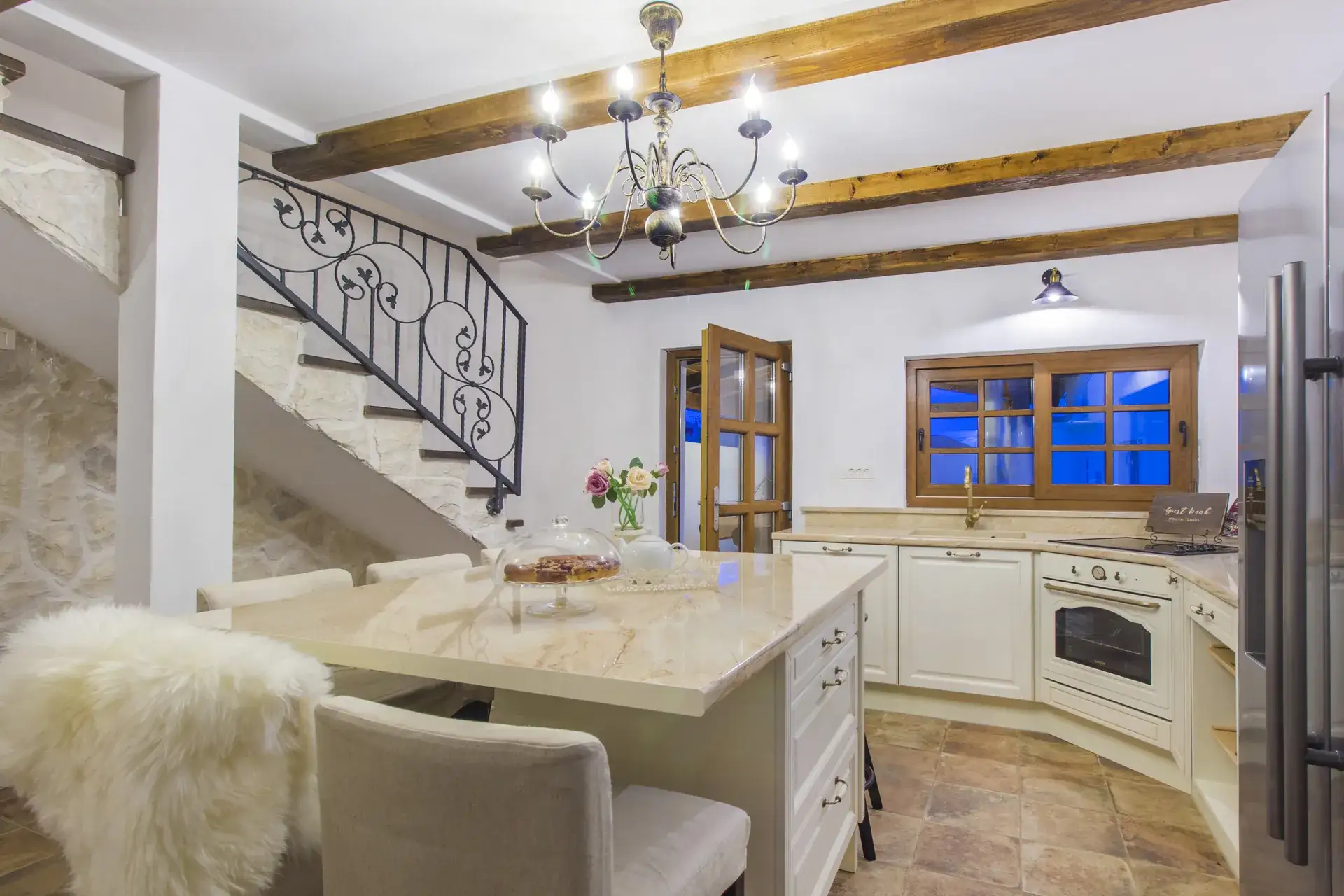 Kitchen island with the staircase behind and the door to the terrace