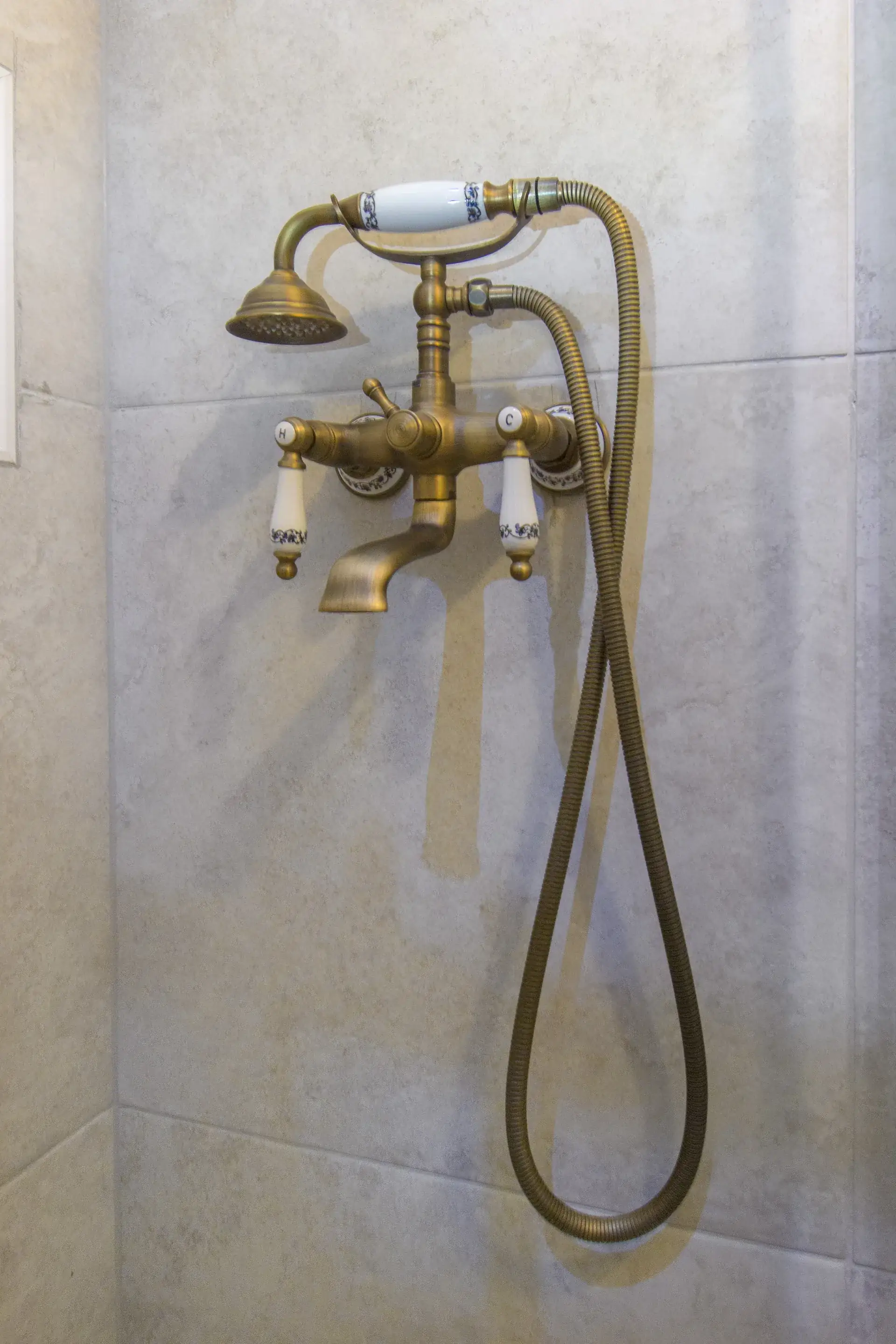 Brass rain shower fitting in the tiled walk-in shower