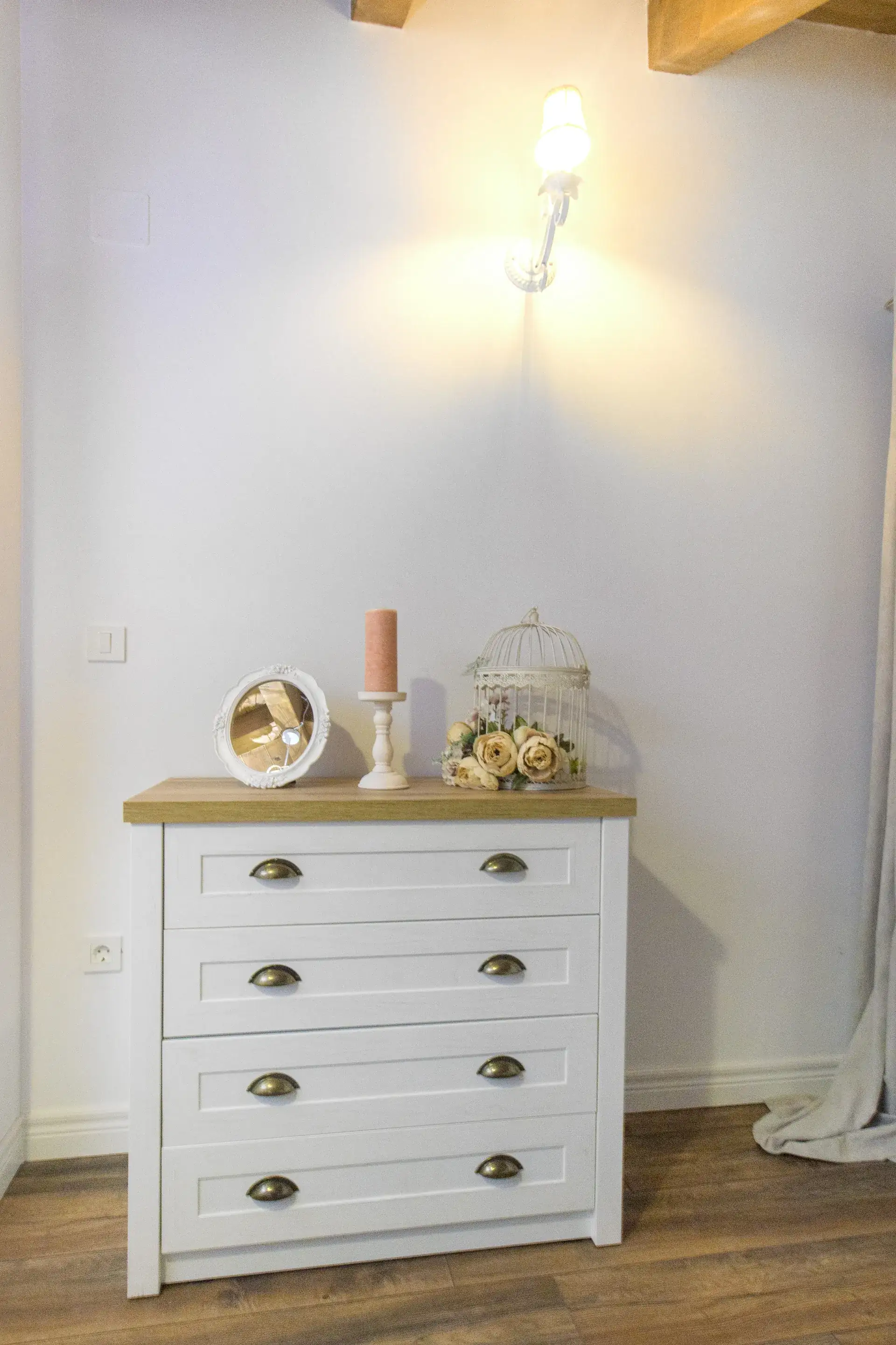 White chest of drawers and bedside lamp in the bedroom