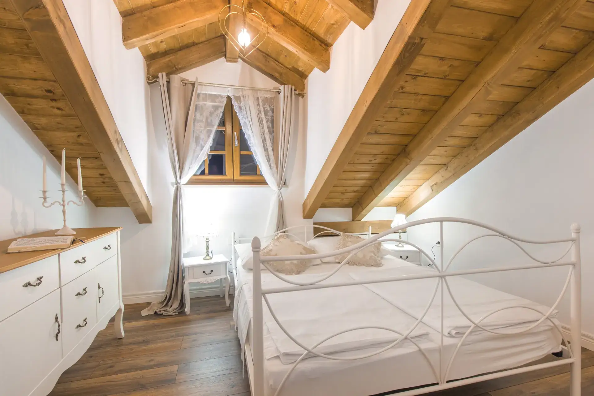 Attic bedroom with a double bed and wooden beamed ceiling at House Leila