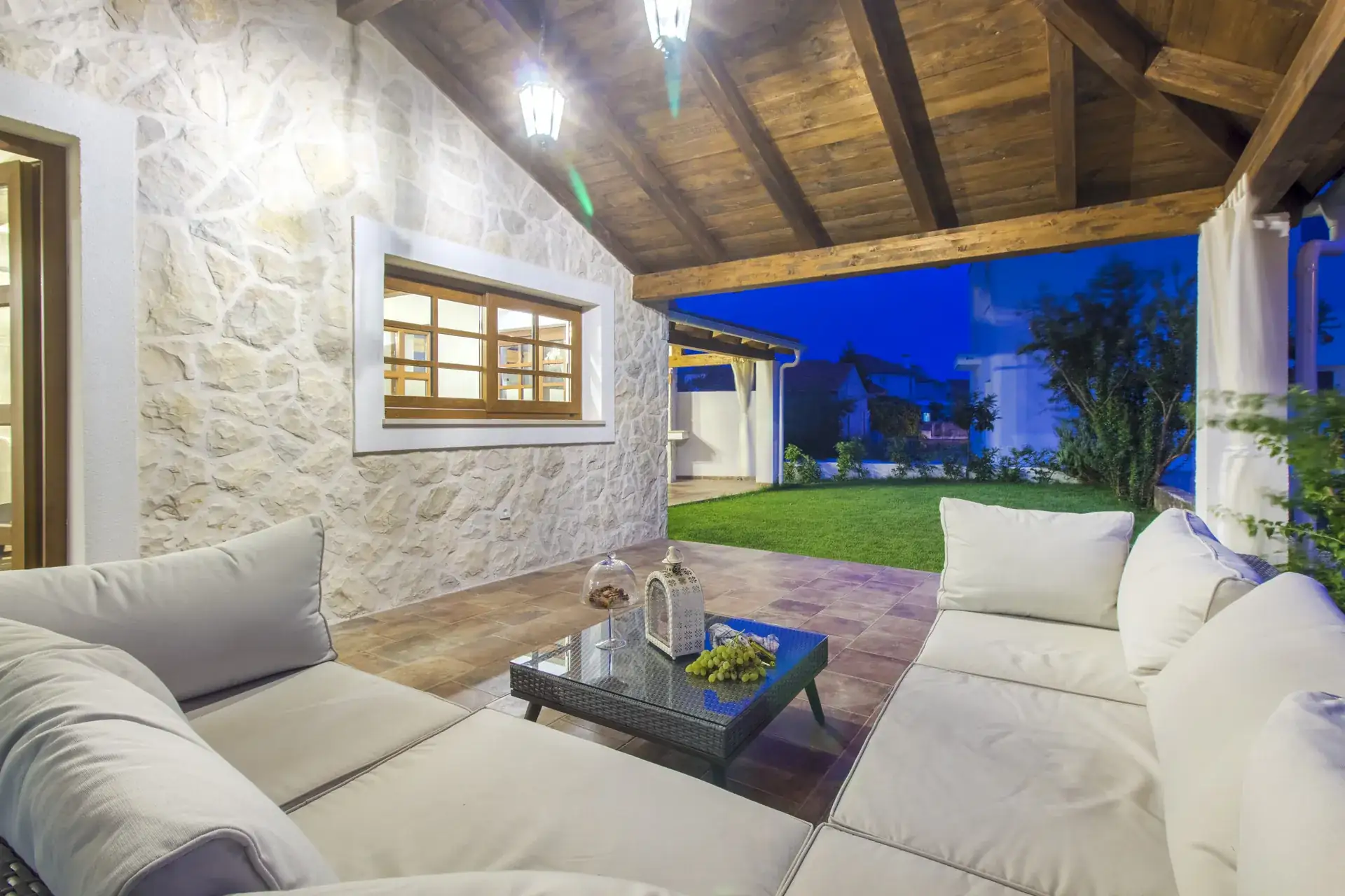 Garden lounge beside the stone wall as the light fades