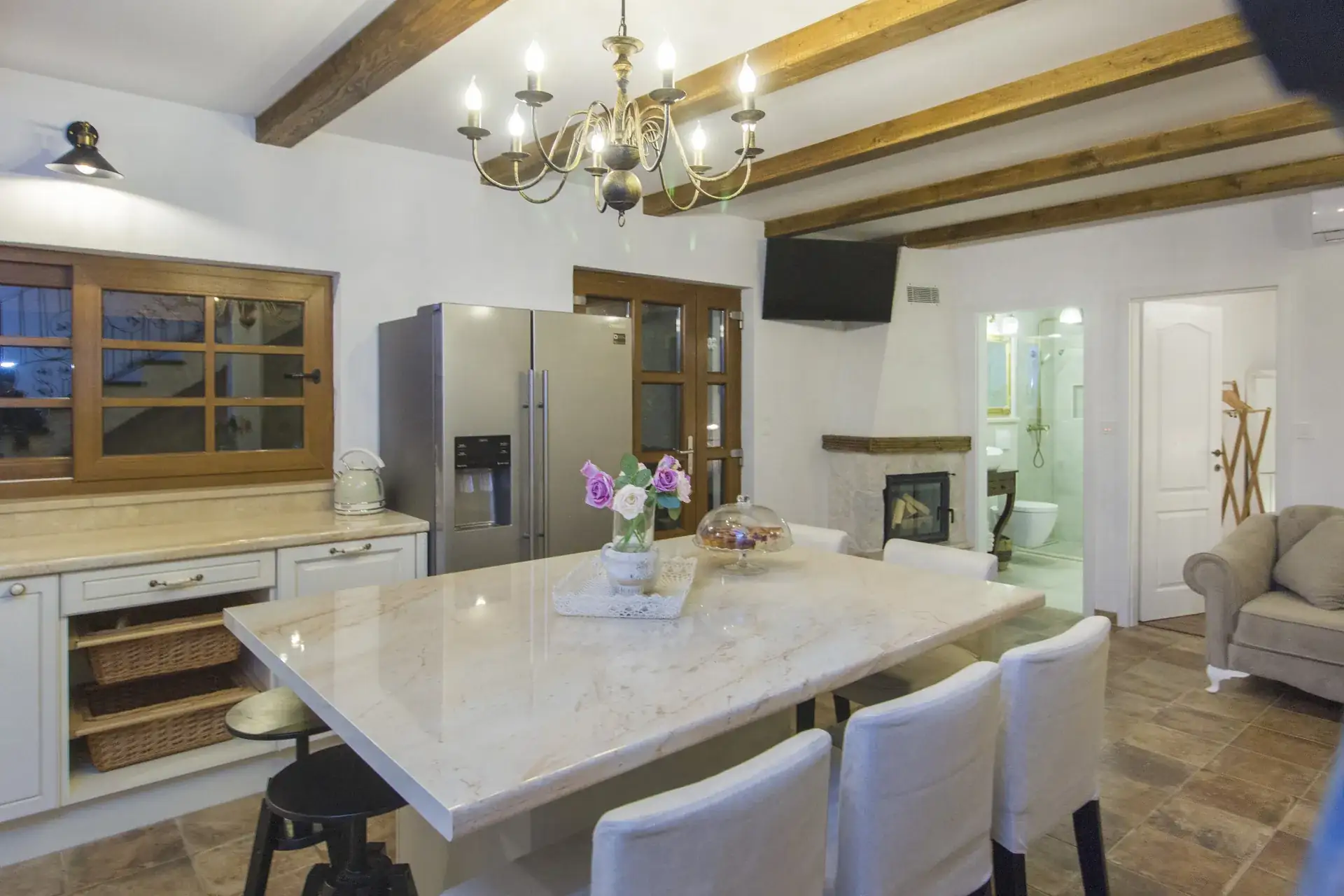 Open kitchen with a marble island and breakfast seating, looking through to the living room