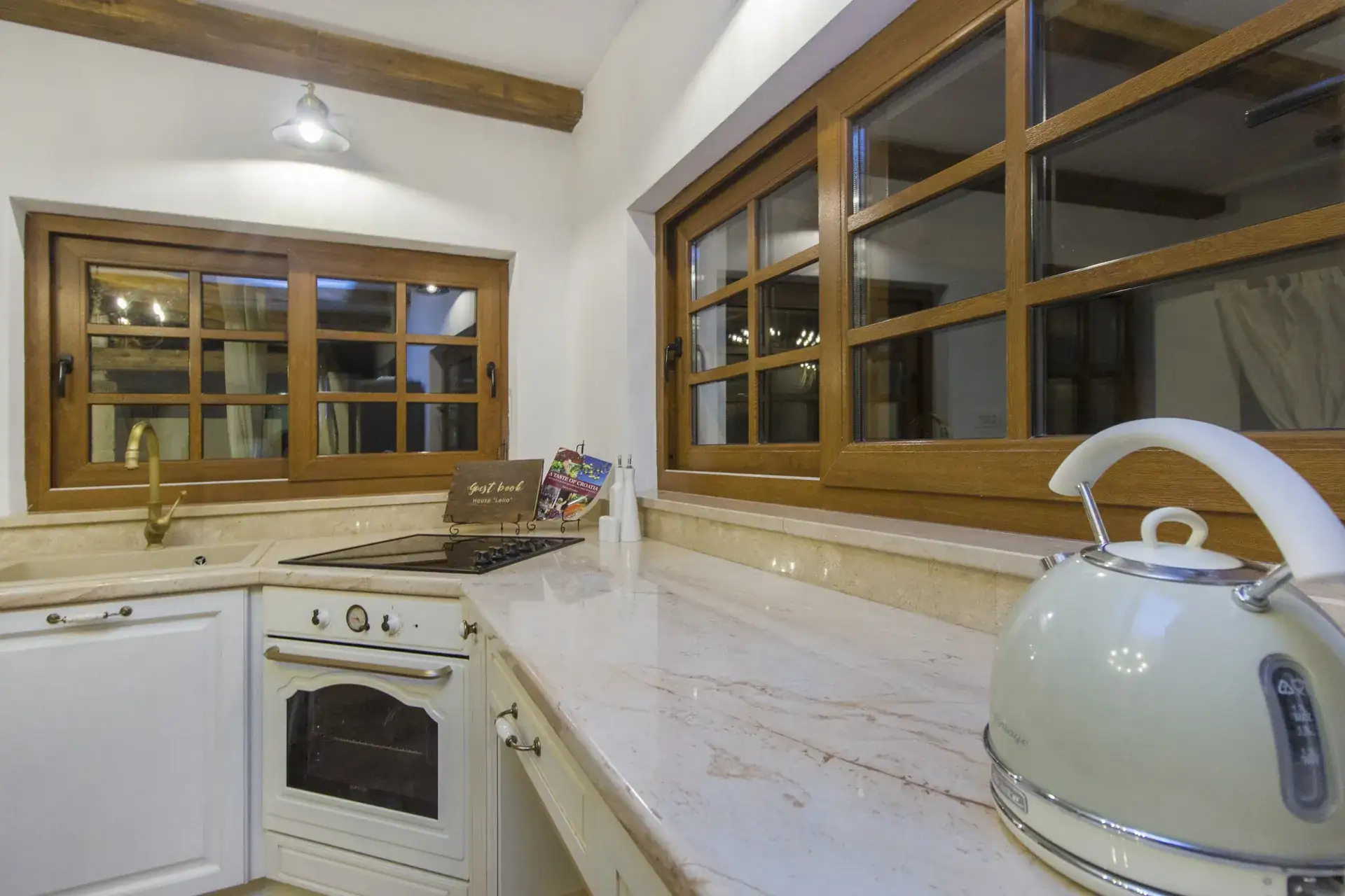 Kitchen worktop with oven, kettle and windows above