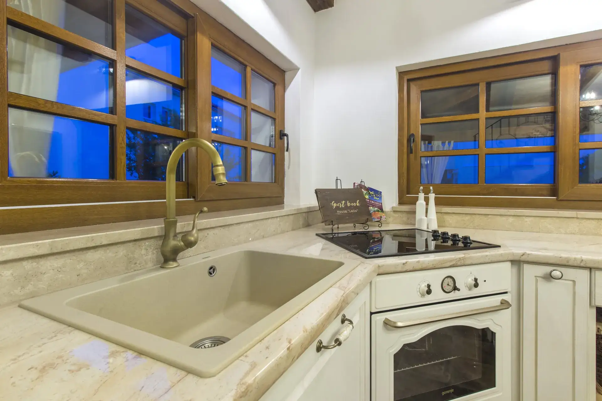 Kitchen sink with brass tap beside the oven and hob